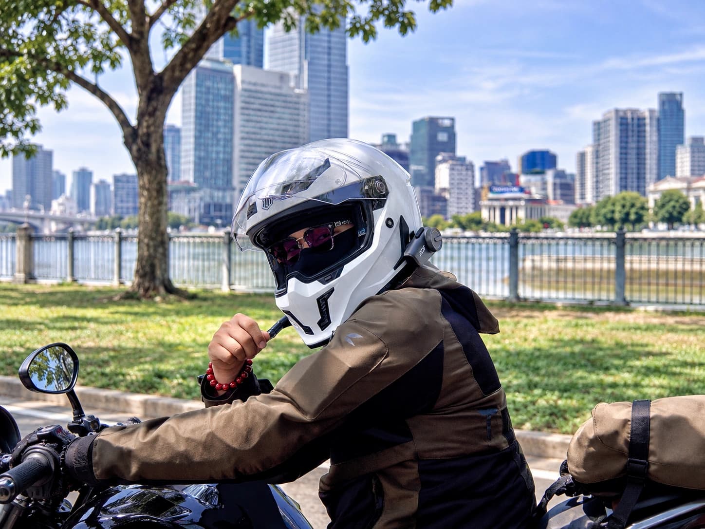 The riding partner picks music while stopped at a fuel station.
